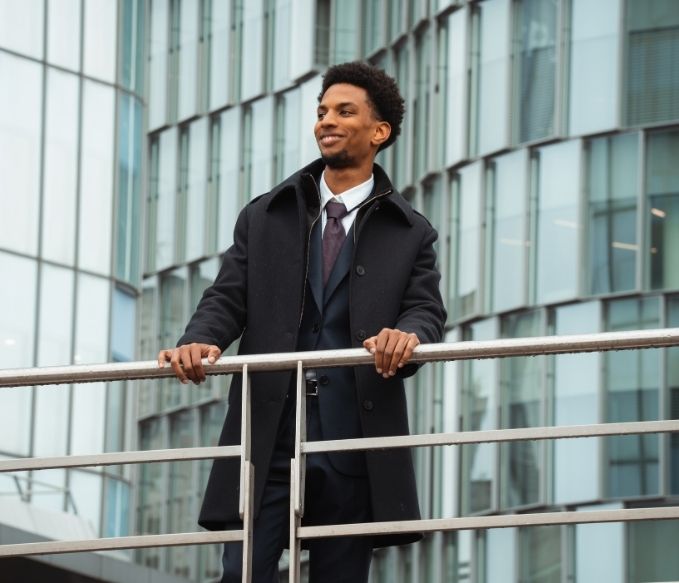 Etudiant regarde à l'horizon dans une tenue professionnelle entouré de bâtiment à Paris La Défense